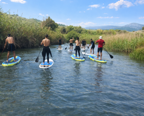 grupo de alumnos practicando paddlesurf en una salida escolar del instituto