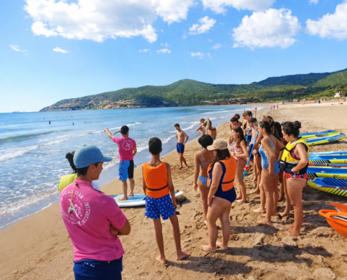 Alumnos participando de un dia de actividades acuaticas en una salida de un dia a la playa desde el instituto